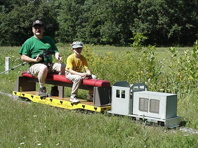 Photo of big man,little train!